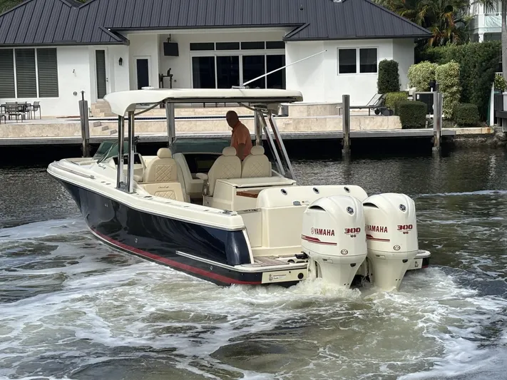  Yacht Photos Pics 2019 Chris-Craft Calypso 30 boat with twin Yamaha engines near a waterfront house.