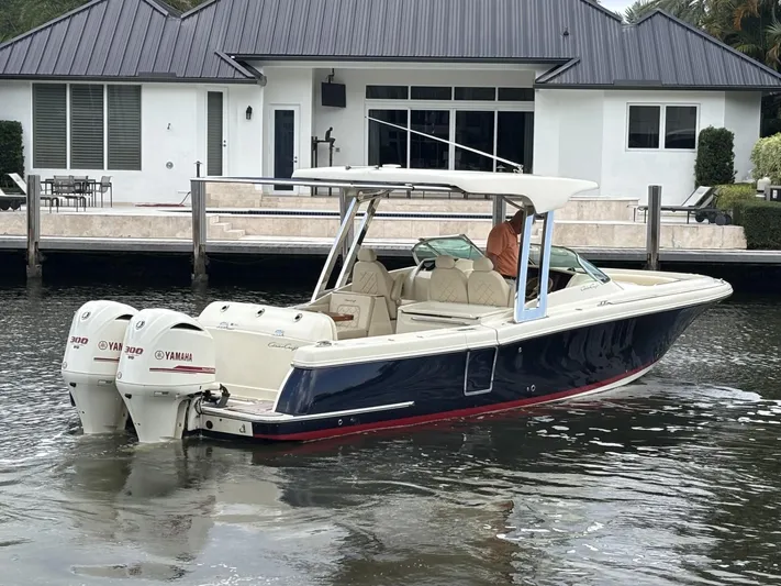  Yacht Photos Pics 2019 Chris-Craft Calypso 30 boat with dual Yamaha engines near a modern waterfront home.