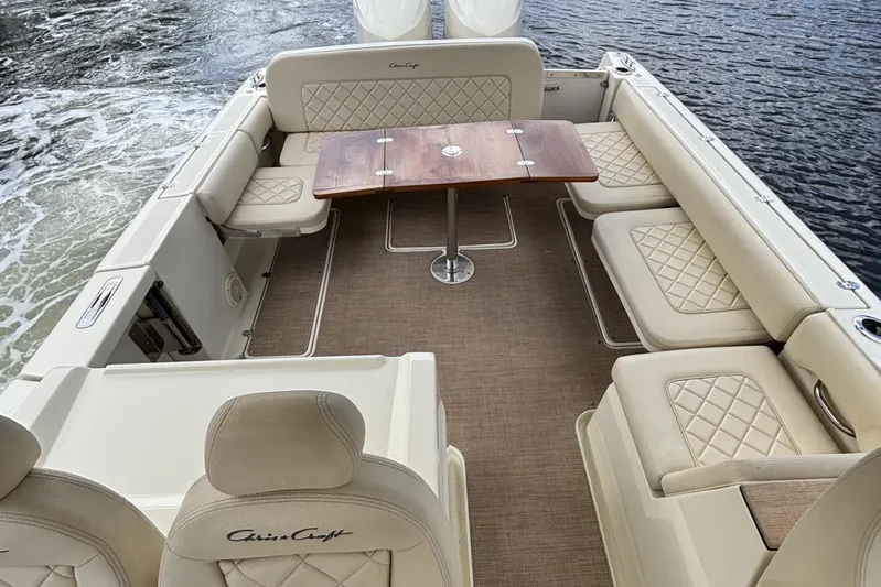  Yacht Photos Pics 2019 Chris-Craft Calypso 30 boat interior with beige seating and wooden table.
