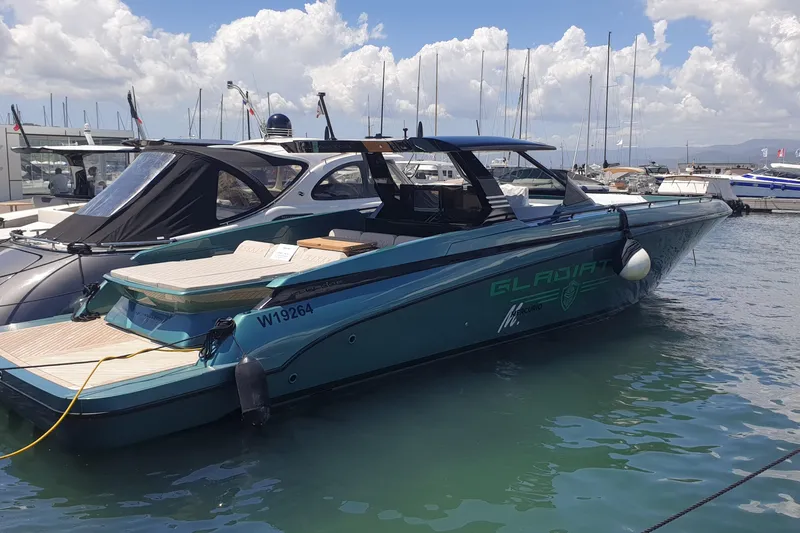  Yacht Photos Pics 2023 Canados Gladiator 493 yacht docked in a marina under a partly cloudy sky.