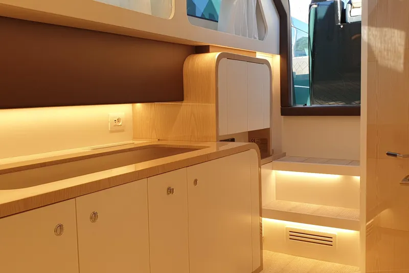  Yacht Photos Pics Luxurious interior of 2023 Canados Gladiator 493 yacht with modern wood finishes and ambient lighting.