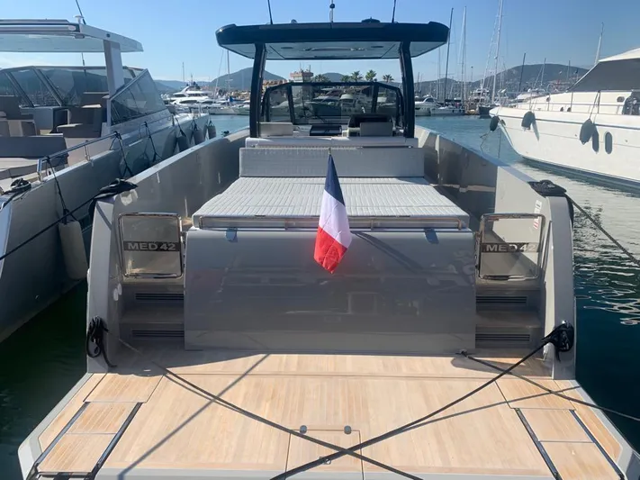 Yacht Photos Pics 2023 MedYacht 42 docked, featuring sleek design and French flag, in a sunny marina.