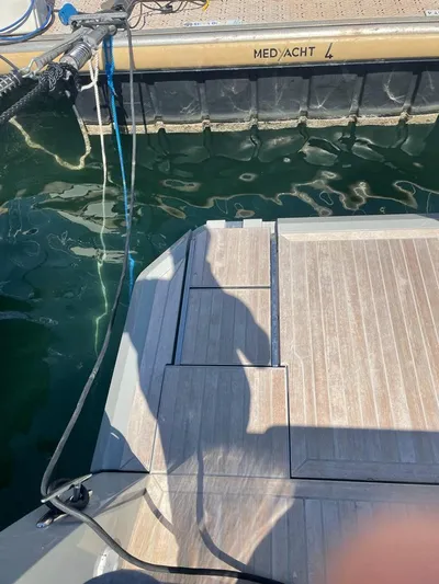  Yacht Photos Pics 2023 MedYacht 42 docked, showing wooden deck and water reflection.