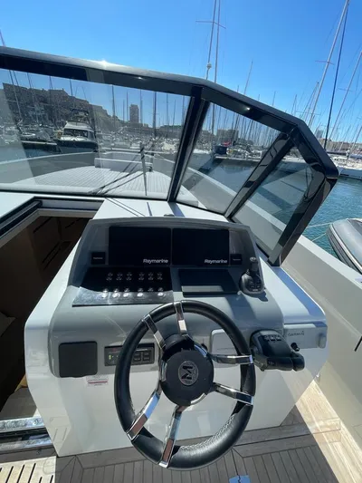  Yacht Photos Pics Helm of 2023 MedYacht 42 with modern navigation equipment in a marina setting.