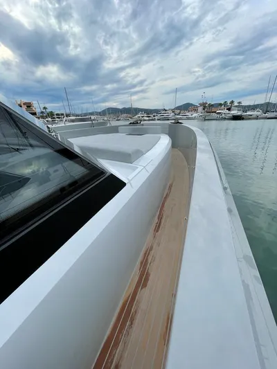  Yacht Photos Pics 2023 MedYacht 42 docked, showcasing sleek design and wooden deck under cloudy sky.