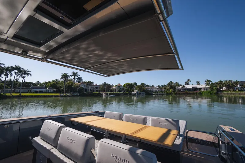  Yacht Photos Pics 2025 Pardo Yachts 43 on serene waterway, featuring luxurious seating and retractable canopy.