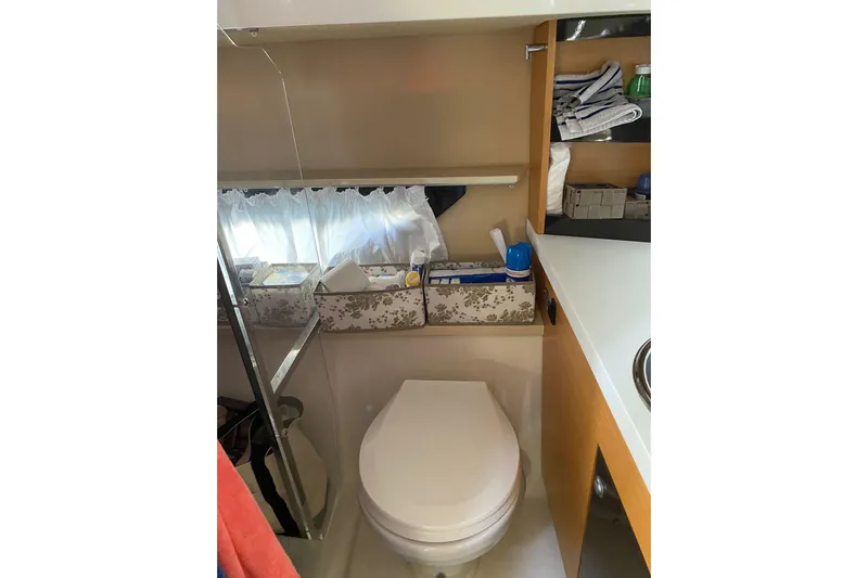  Yacht Photos Pics 2009 Cranchi Endurance 33 yacht bathroom with toilet, storage shelves, and toiletries.