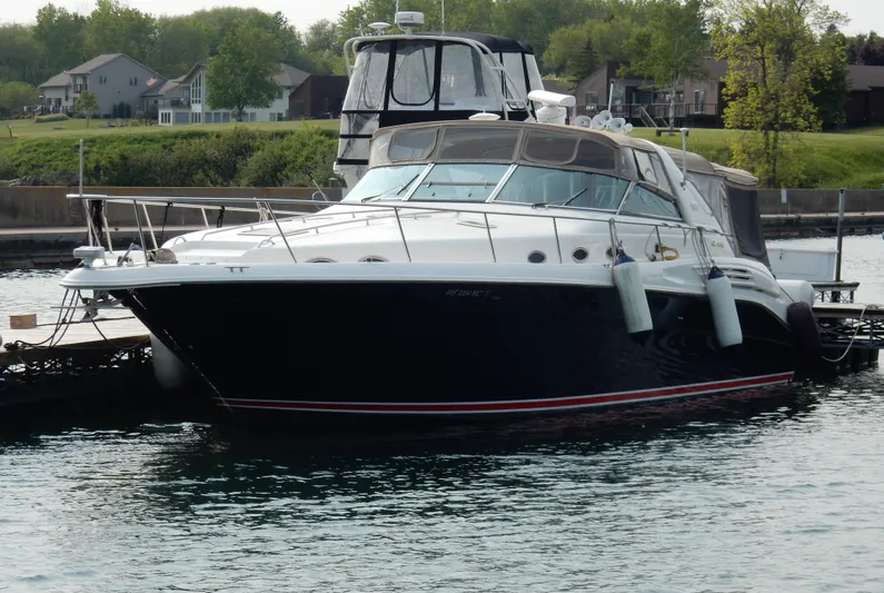 Sandi Yacht Photos Pics 1997 Sea Ray 450 yacht docked in a marina, surrounded by calm water and greenery.