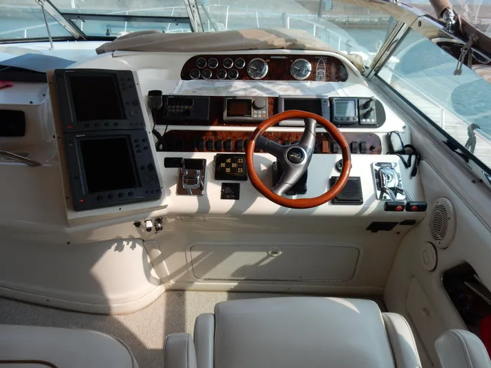 Sandi Yacht Photos Pics 1997 Sea Ray 450 yacht helm with wooden steering wheel and navigation instruments.