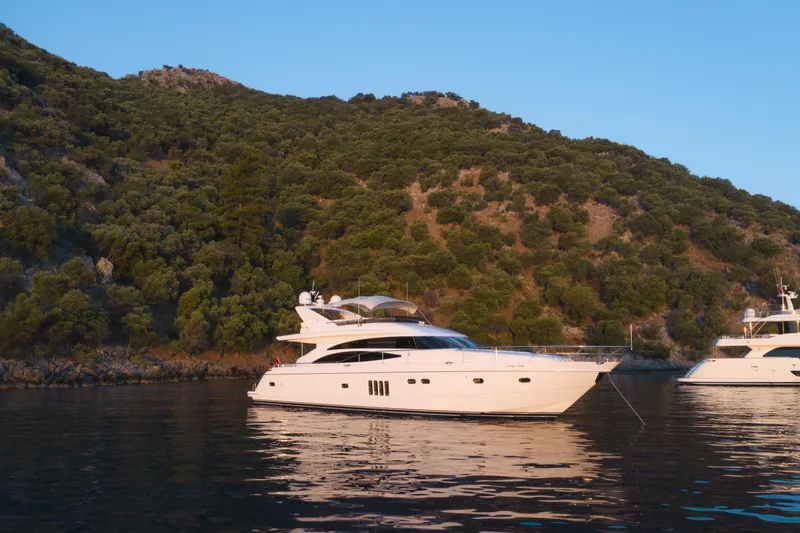  Yacht Photos Pics Luxury 2007 Princess 21M yacht anchored near scenic, tree-covered hillside.