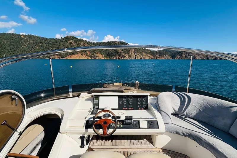  Yacht Photos Pics Cockpit view of 2007 Princess 21M yacht on serene blue water with scenic hills.