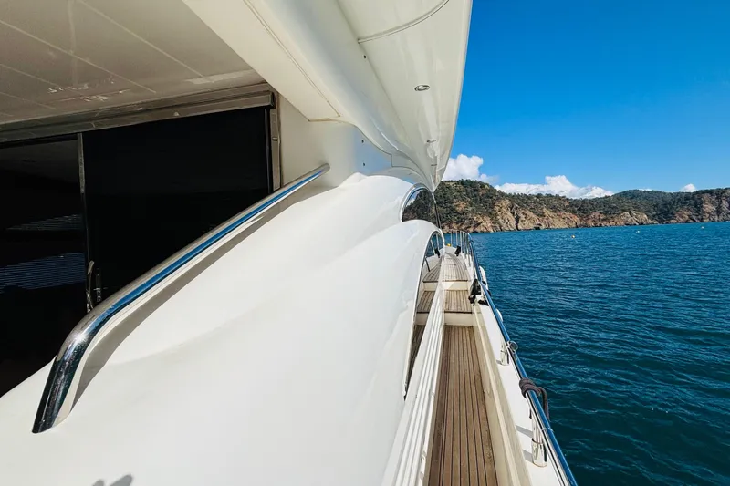  Yacht Photos Pics Side view of 2007 Princess 21M yacht cruising near rocky coastline.