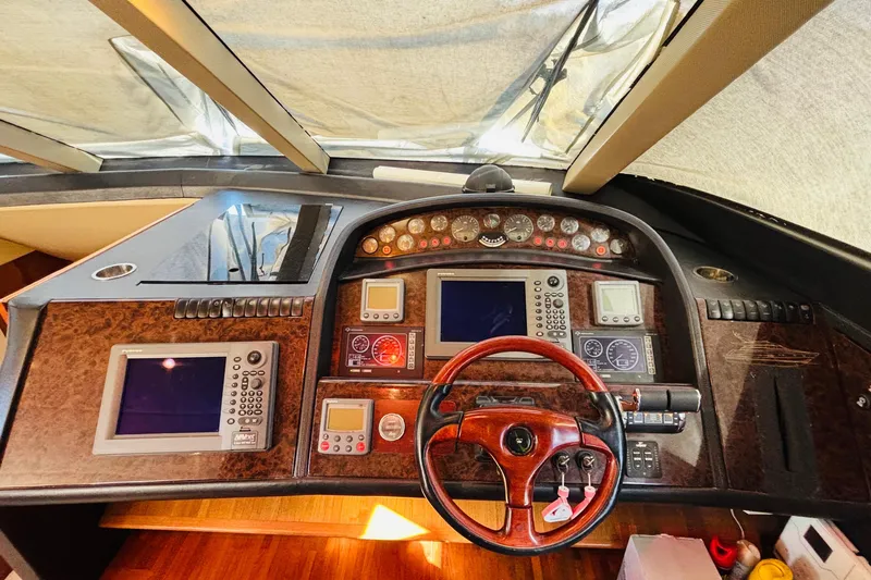  Yacht Photos Pics Cockpit of 2007 Princess 21M yacht with navigation controls and wooden steering wheel.