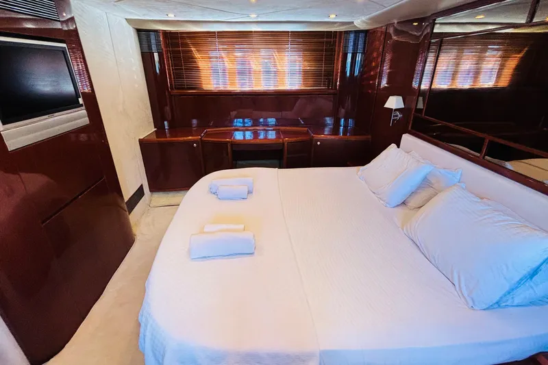  Yacht Photos Pics Luxurious cabin interior of 2007 Princess 21M yacht with elegant wood finishes and cozy bedding.