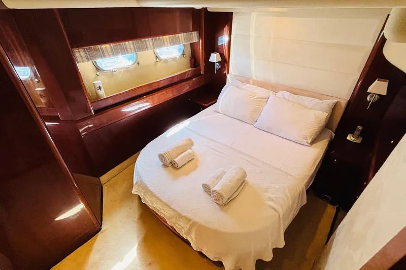  Yacht Photos Pics Luxurious cabin interior of 2007 Princess 21M yacht with cozy bed and elegant wood finish.
