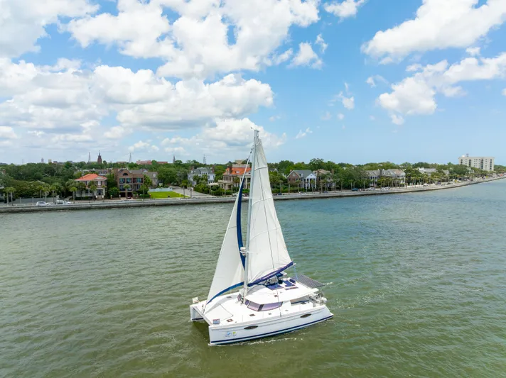 Starry Night Yacht Photos Pics Sailing catamaran Fountaine Pajot Helia 44, 2014, cruising near a scenic waterfront.