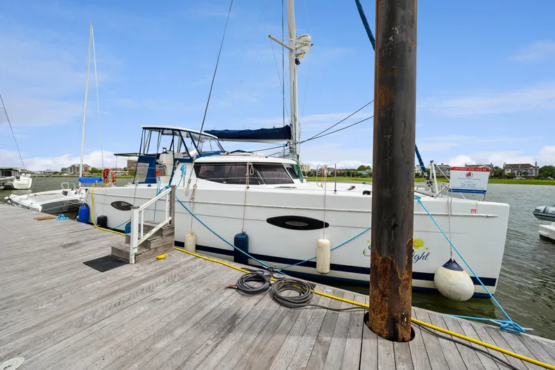 Starry Night Yacht Photos Pics 2014 Fountaine Pajot Helia 44 catamaran docked at a marina, clear sky background.