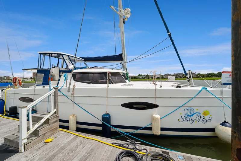 Starry Night Yacht Photos Pics 2014 Fountaine Pajot Helia 44 catamaran docked, named "Starry Night," under clear blue sky.
