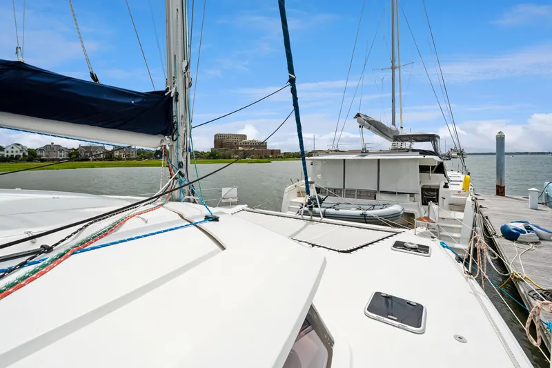 Starry Night Yacht Photos Pics 2014 Fountaine Pajot Helia 44 catamaran docked at marina, clear sky, waterfront homes.