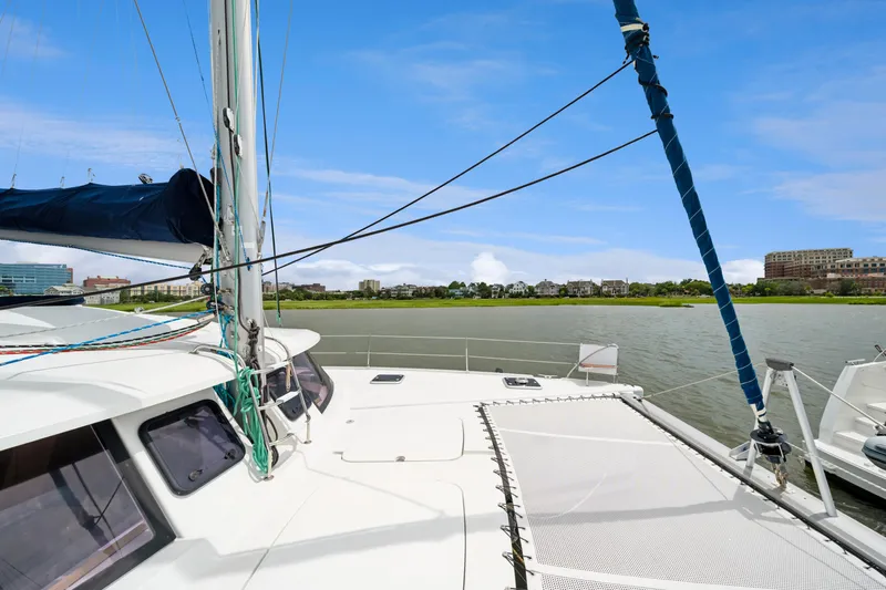 Starry Night Yacht Photos Pics 2014 Fountaine Pajot Helia 44 catamaran on calm waters with cityscape background.