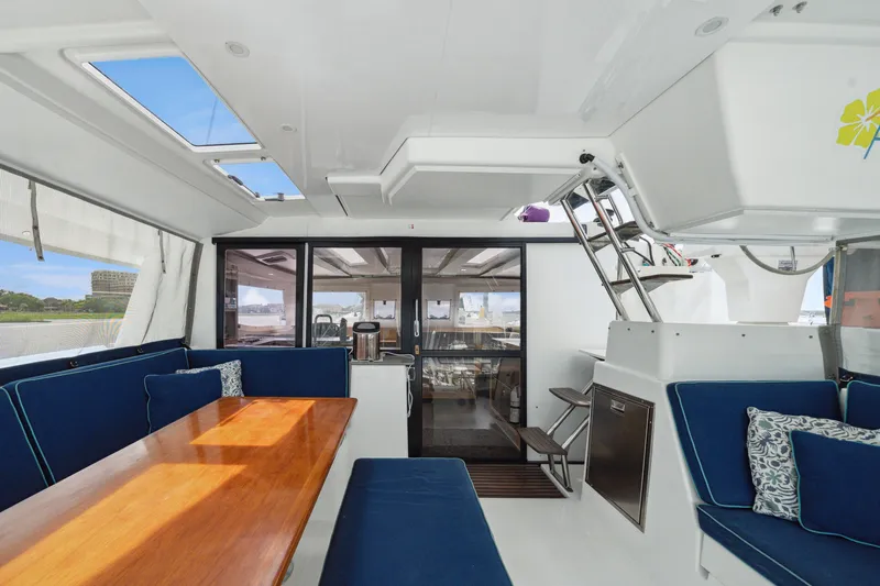 Starry Night Yacht Photos Pics Interior of 2014 Fountaine Pajot Helia 44 catamaran with blue seating and wooden table.