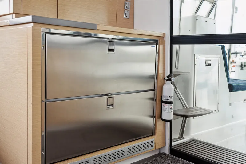 Starry Night Yacht Photos Pics Interior of 2014 Fountaine Pajot Helia 44 yacht with stainless steel drawers and fire extinguisher.