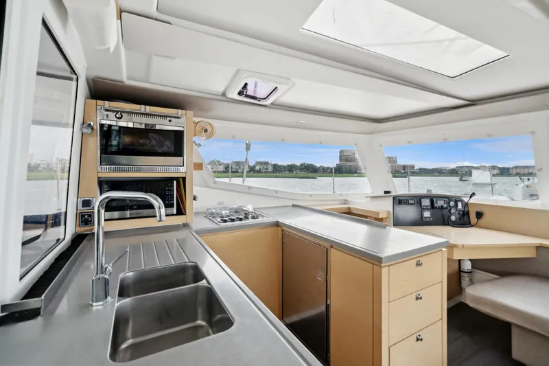 Starry Night Yacht Photos Pics Interior of 2014 Fountaine Pajot Helia 44 catamaran with modern kitchen and navigation area.