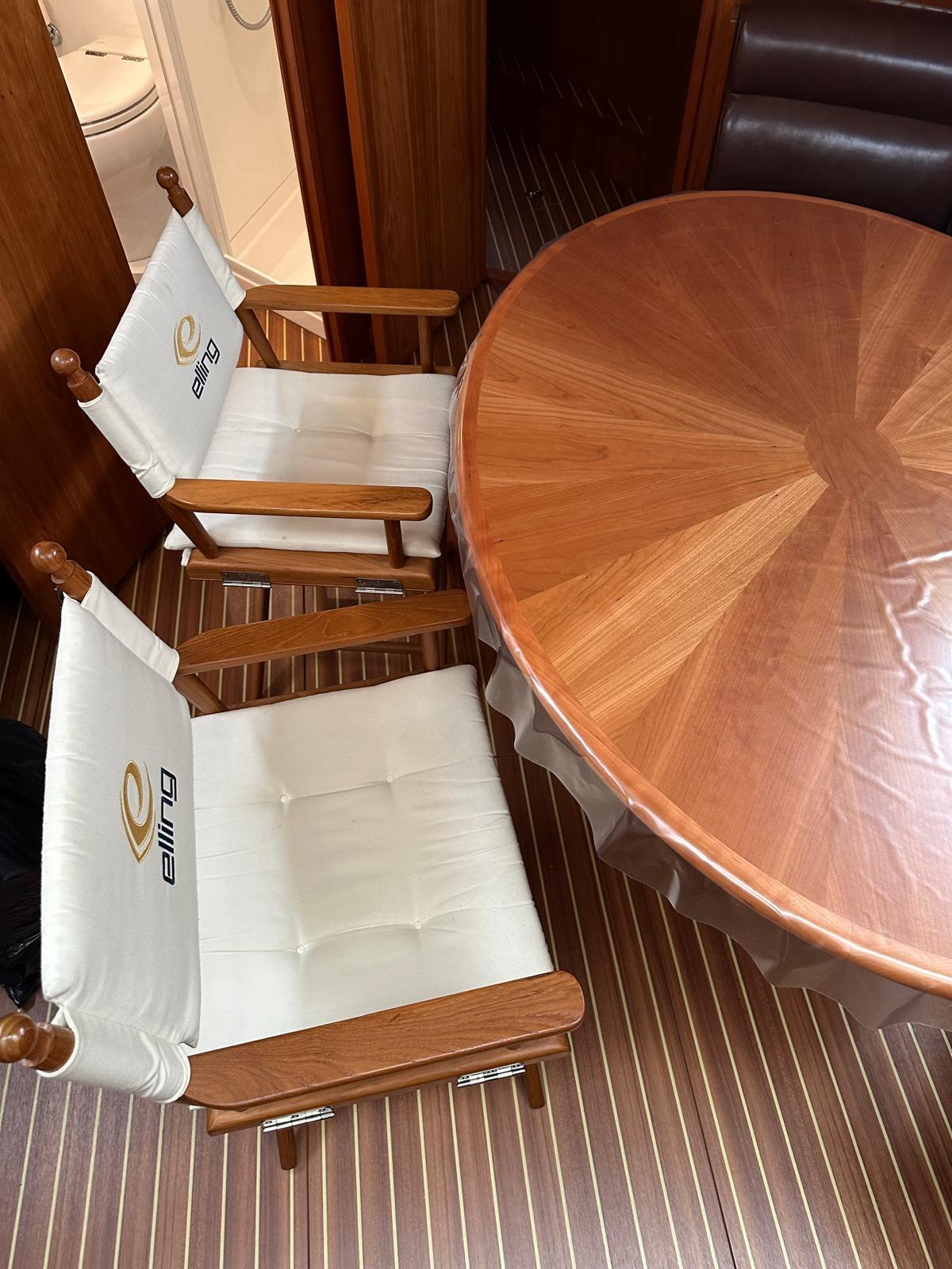 Luxury yacht interior with wooden table and branded Elling chairs, 2018 Elling E4 Ultimate.