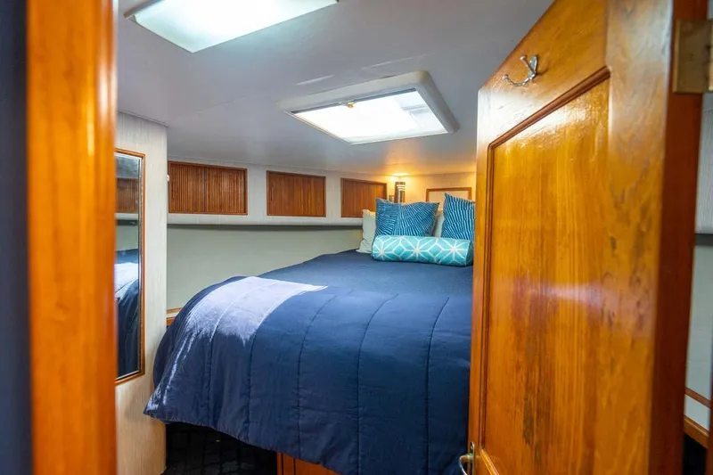  Yacht Photos Pics Cozy cabin interior of 1993 Buddy Davis Express Custom Carolina boat with blue bedding.