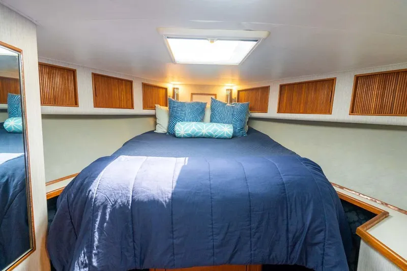  Yacht Photos Pics Cozy cabin interior of 1993 Buddy Davis Express Custom Carolina with blue bedding and wooden accents.