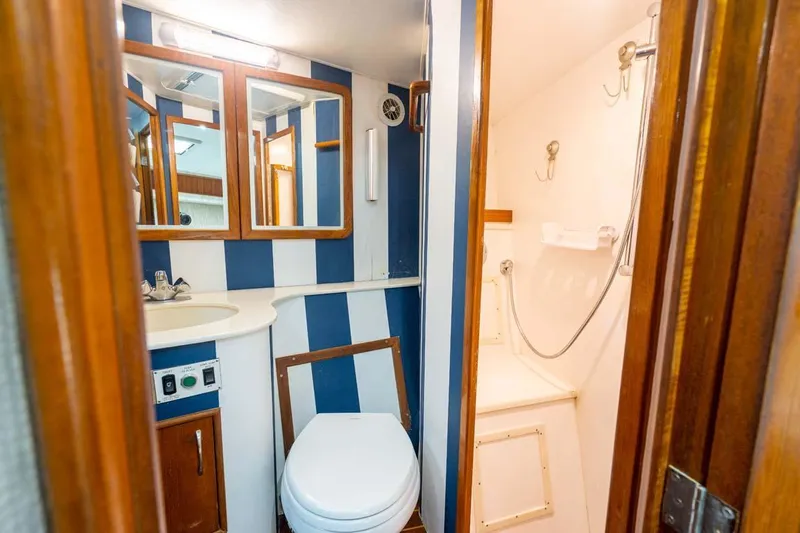  Yacht Photos Pics Bathroom interior of 1993 Buddy Davis Express Custom Carolina boat, featuring striped walls and compact design.