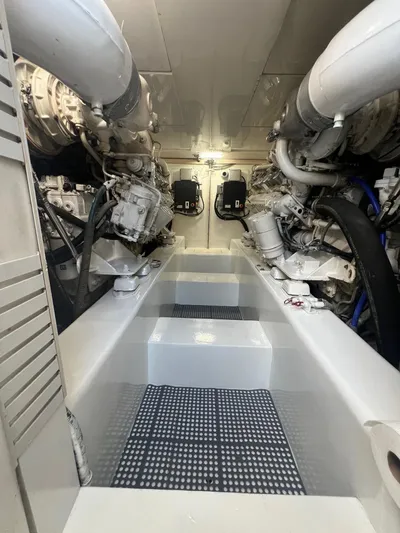 Quite Nice Yacht Photos Pics Engine room of a 2004 Bertram 570 Convertible yacht, showcasing dual engines and mechanical components.