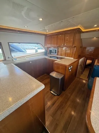 Quite Nice Yacht Photos Pics 2004 Bertram 570 Convertible yacht interior with modern kitchen and wooden cabinetry.