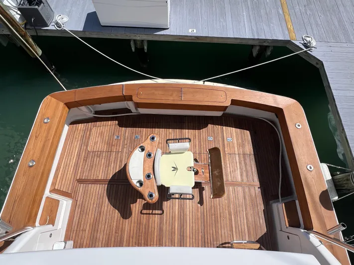 Quite Nice Yacht Photos Pics 2004 Bertram 570 Convertible yacht deck with wooden flooring and fishing chair.