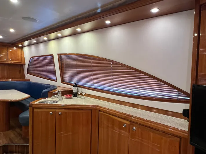 Quite Nice Yacht Photos Pics Interior of 2004 Bertram 570 Convertible yacht with wood cabinetry and seating area.