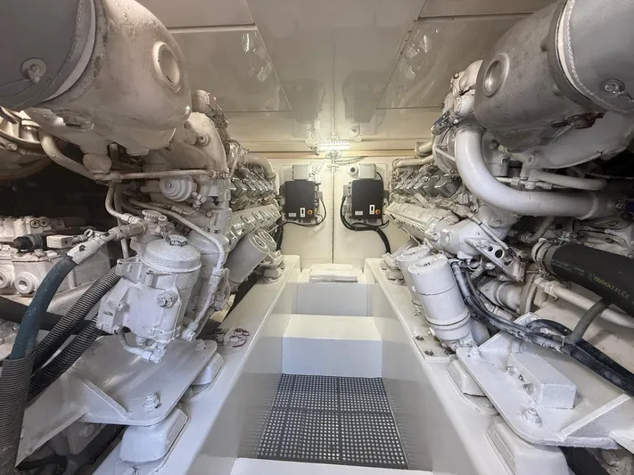Quite Nice Yacht Photos Pics Engine room of a 2004 Bertram 570 Convertible yacht, showcasing dual engines and mechanical components.