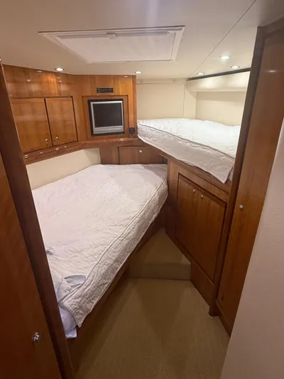 Quite Nice Yacht Photos Pics 2004 Bertram 570 Convertible cabin with wooden interior, twin beds, and built-in TV.