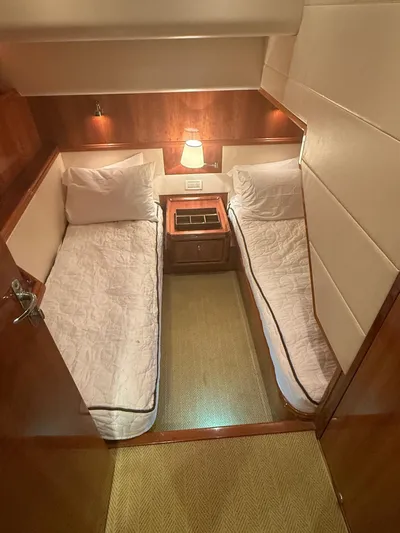 Quite Nice Yacht Photos Pics 2004 Bertram 570 Convertible cabin with twin beds and warm lighting.