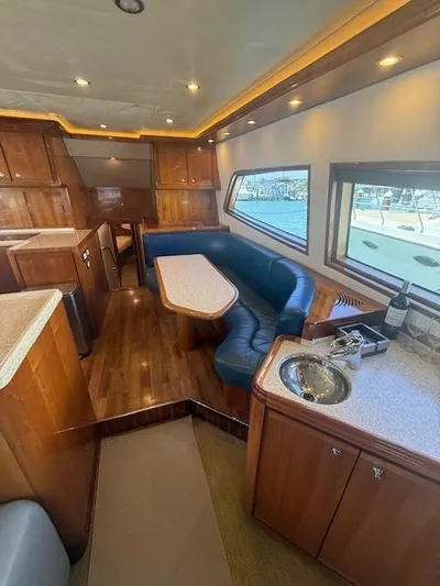 Quite Nice Yacht Photos Pics Interior of 2004 Bertram 570 Convertible yacht with luxurious seating and wooden cabinetry.