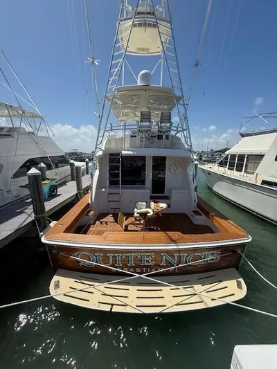 Quite Nice Yacht Photos Pics 2004 Bertram 570 Convertible yacht docked at marina, rear view with clear sky.