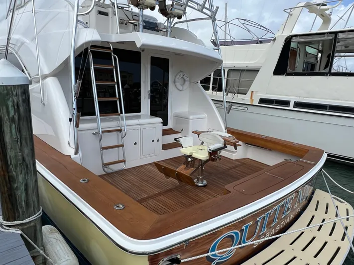 Quite Nice Yacht Photos Pics 2004 Bertram 570 Convertible yacht with wooden deck and fishing chair at marina.