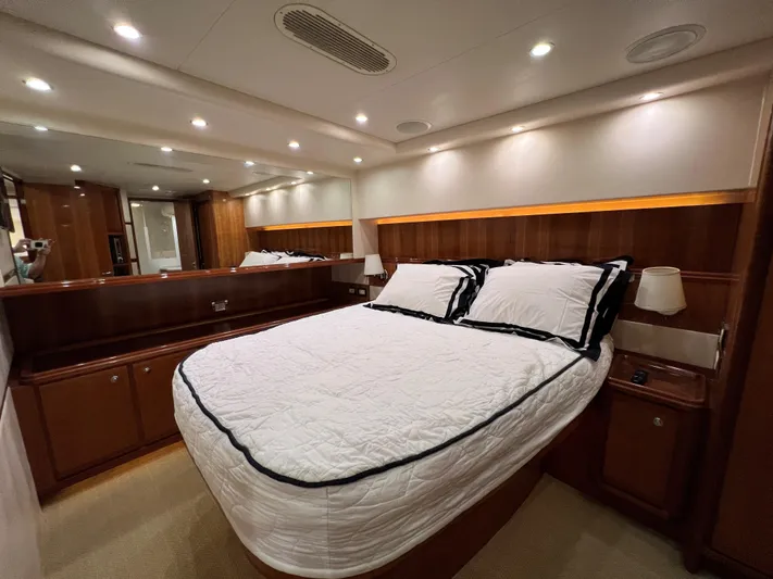 Quite Nice Yacht Photos Pics Luxurious bedroom interior of 2004 Bertram 570 Convertible yacht with elegant wood paneling.