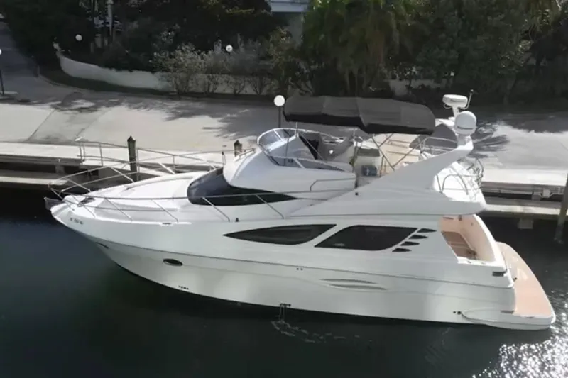  Yacht Photos Pics 2005 Silverton 43 Sport Bridge yacht docked in a serene marina setting.