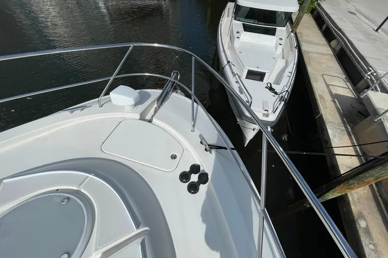  Yacht Photos Pics 2005 Silverton 43 Sport Bridge yacht docked beside another boat in a marina.