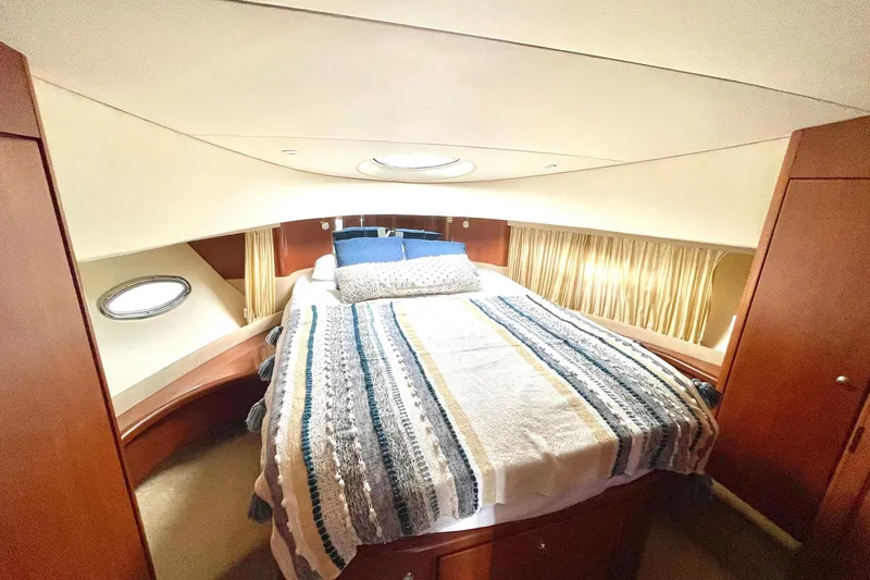  Yacht Photos Pics Luxurious cabin interior of 2005 Silverton 43 Sport Bridge yacht with cozy bed and porthole.