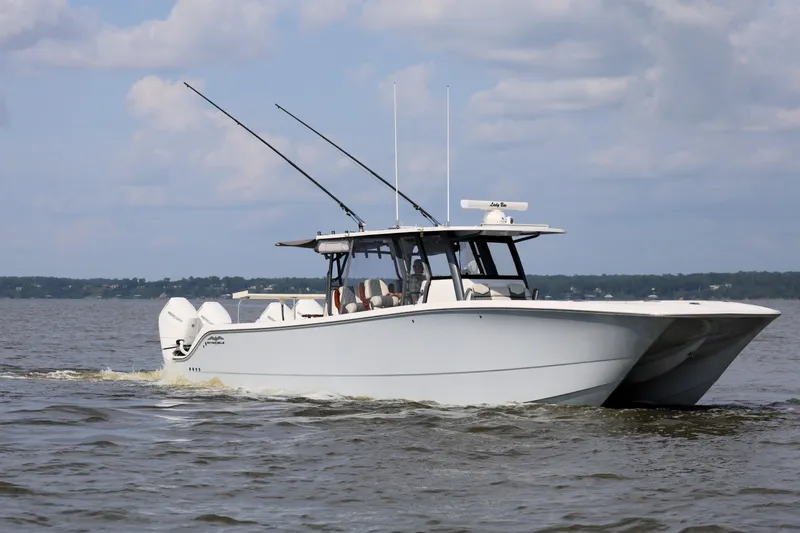  Yacht Photos Pics 2022 Invincible 46 Catamaran cruising on open water under a cloudy sky.