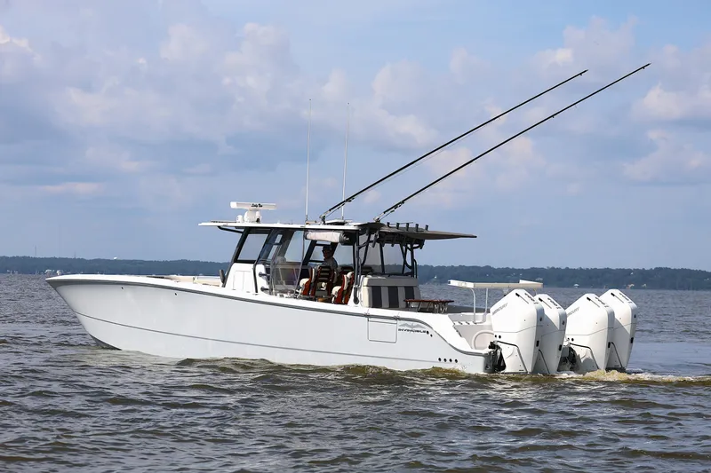  Yacht Photos Pics 2022 Invincible 46 Catamaran cruising on open water under a cloudy sky.