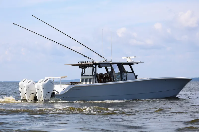  Yacht Photos Pics 2022 Invincible 46 Catamaran cruising on open water, featuring multiple outboard engines.