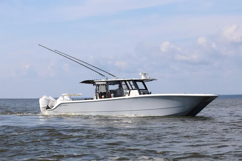 Yacht Photos Pics 2022 Invincible 46 Catamaran cruising on open water under a clear sky.