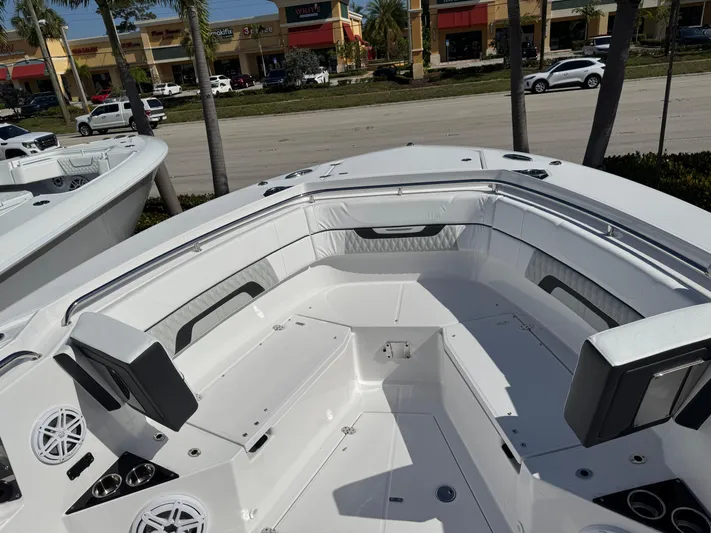  Yacht Photos Pics 2025 Blackfin 332 CC boat interior with seating and speakers, parked near a road.